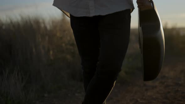 Attractive Bearded Caucasian Man with Guitar Standing and Looking at Camera After He Finished Phone