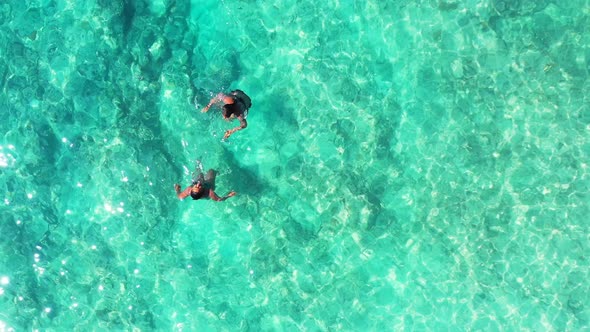 Two people snorkel in clear Caribbean water. two girls having fun on tropical vacation