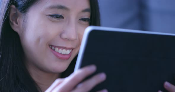 Woman watching drama on tablet computer at home in the evening