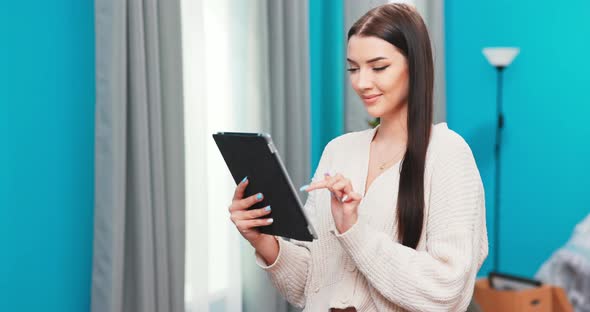 Happy Young Woman Relaxing at Home Holding Digital Tablet Enjoying Surfing Internet Study Work