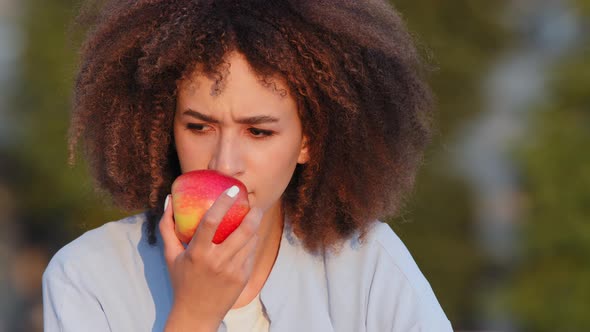 Close Up Afro American Woman African Curly Girl Sitting Outdoors Sniffs Red Fresh Ripe Apple