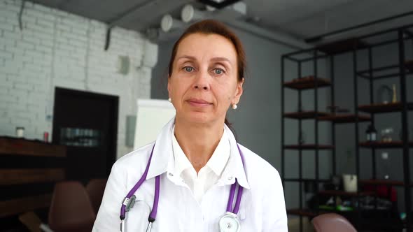 Woman Doctor in White Coat with Stethoscope Listening of Patient or Colleagues