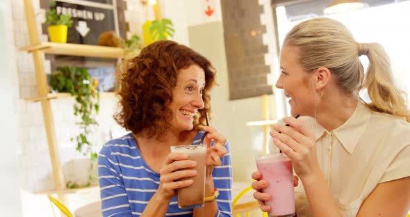 Female executives interacting while having milkshake 4k