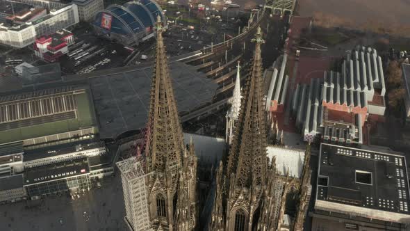 AERIAL: Close Up Circling Around Cologne Cathedral with Central Train Station in Beautiful Hazy