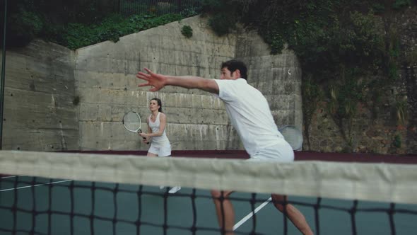 Woman and man playing tennis on a court