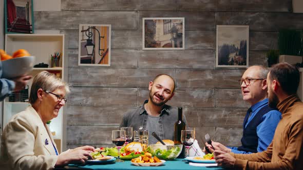 Young Woman Bringing a Basket of Fruits at Family Dinner