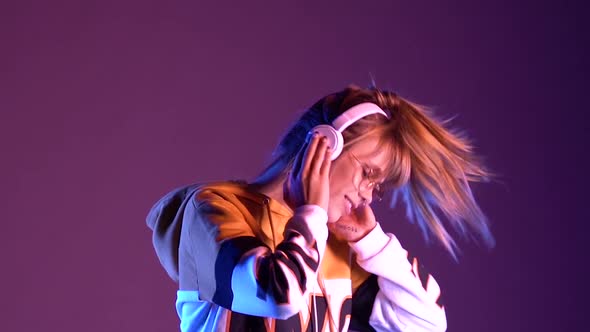 Happy Teen Girl Wear Headphones Listen Music Dance in Purple Neon Slow Motion