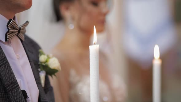 Newlyweds. Caucasian Bride and the Groom Stand in Church with Candles at Wedding Ceremony