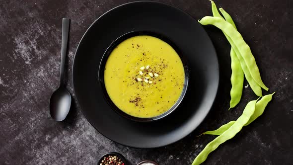 Creamy Soup with Green Pea in a Ceramic White Plate