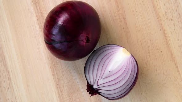 Red onion rotating top view on wooden background