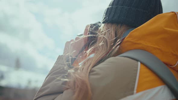 Young woman taking pictures with a digital photo camera and reviewing them. Handheld closeup