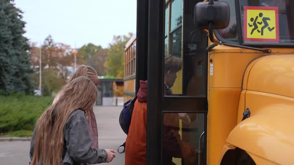 Diverse Teenage Students Entering Bus After Study