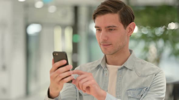 Portrait of Creative Young Man Celebrating on Smartphone