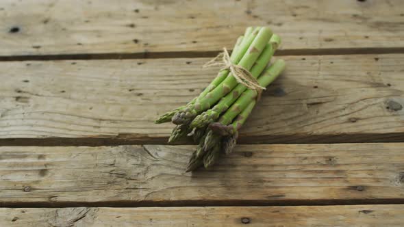 Video of fresh asparagus bundle on wooden background