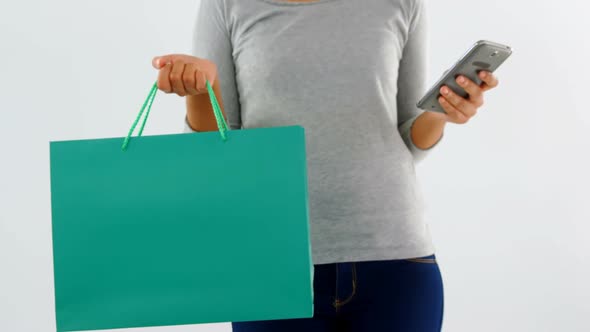 Woman standing with shopping bag and mobile phone 4k