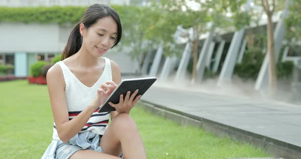 Woman using digital tablet at outdoor park