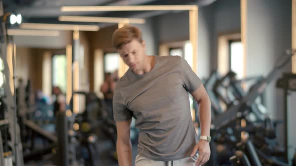 Serious Fitness Man Warming Up in Sport Club. Sportsman Doing Exercises at Gym