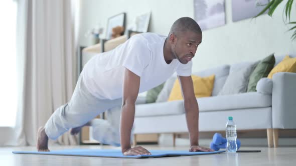 Young African Man Doing Exercise on Yoga Mat at Home