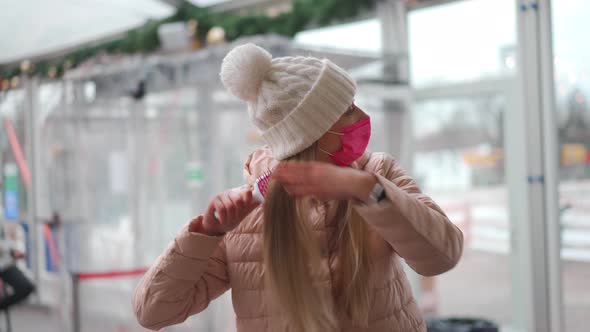 Woman in Pink Protective Medical Mask Brushing His Long Blonde Hair Dressed Winter Clothes White