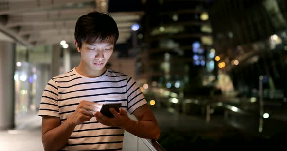 Young man use of mobile phone in the city 