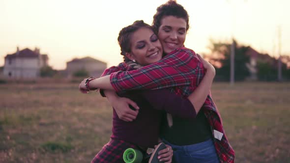 Two Best Friends Hugging Each Other and Looking in the Camera Smiling