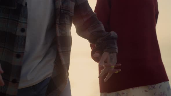 Woman and Man Walking on Sea Shore at Sunrise