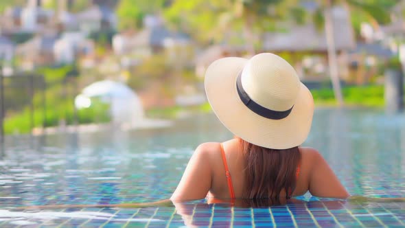 Young asian woman enjoy around outdoor swimming pool for leisure