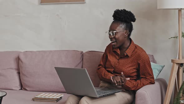 Joyful Black Woman Chatting on Video Call on Laptop at Home