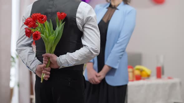 Back View of Nervous Adult Caucasian Man Holding Bouquet of Tulips Gift on Valentine's for Blurred