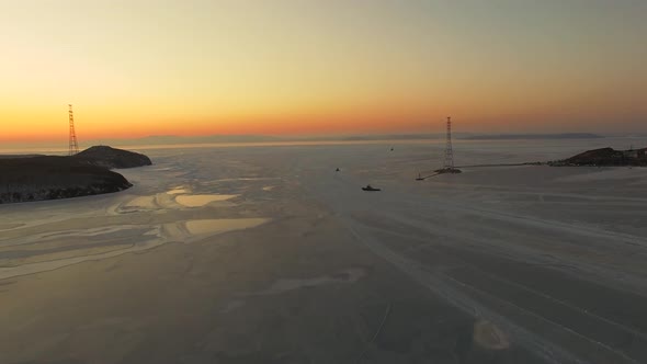 Drone View of the Ice-bound Strait with Tugboats Operating at Sunset