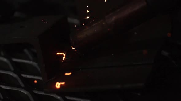 Slow motion of arc welder shooting hot sparks.