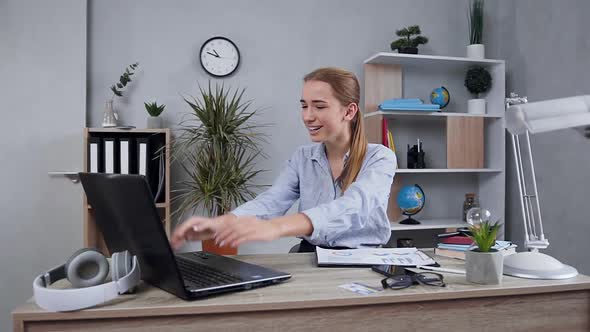 Smiling Lady which Sitting at Her Workplace and Satisfied of Seen Good Results on Computer