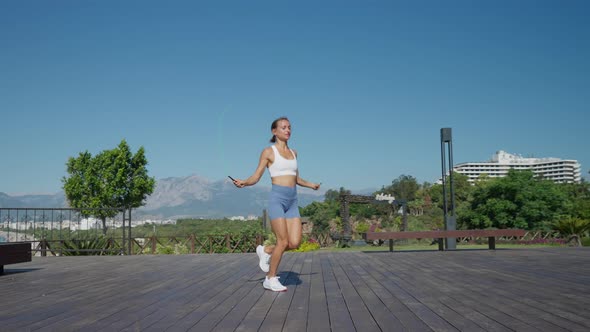 Woman Jumps with Two Skipping Ropes and Does Exercises on Beach