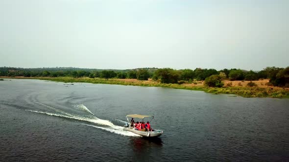 Tourists In Life Vest Ride Speedboat In The Lake, Boat Trip In Africa. - aerial