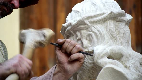 Sculptor or Professional craftsman stone carving a Christ with the crown of thorns