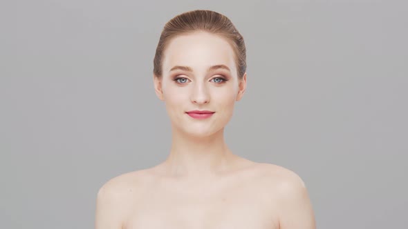 Studio portrait of young, beautiful and natural woman over grey background.