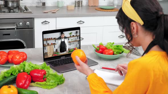 Housewife in Kitchen Tells Chef Shows Ingredients for Cooking in Laptop Webcam