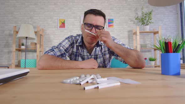 Young Man Sits at a Table Quits Smoking and Is Treated for Addiction