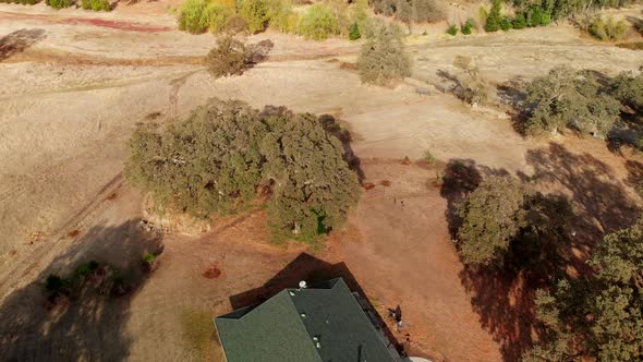 Aerial Drone shot that pans up and around rural farm land from a house