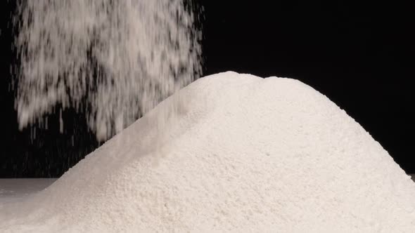 White Flour Falls Down in Slow Motion while a Sieve is Used to Sift.