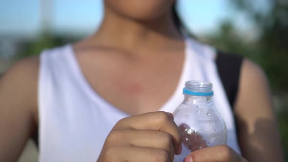 Young woman drinking water after exercise