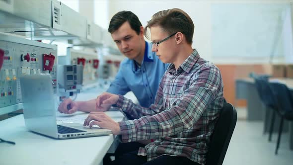 Portrait of a Two Handsome Men Using Laptop in Laboratory