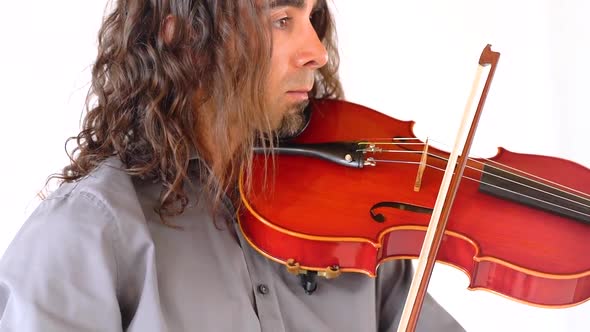 Close up shot of hispanic man in grey shirt with long hair and goatee plays red viola with bow in sl