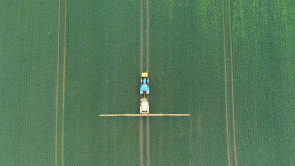 Aerial view of farming tractor crop sprayer in the countryside