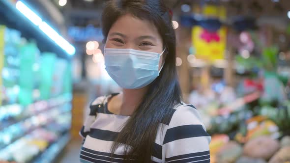 asian female woman wearing facemask smiling with happiness cheerful in groceries