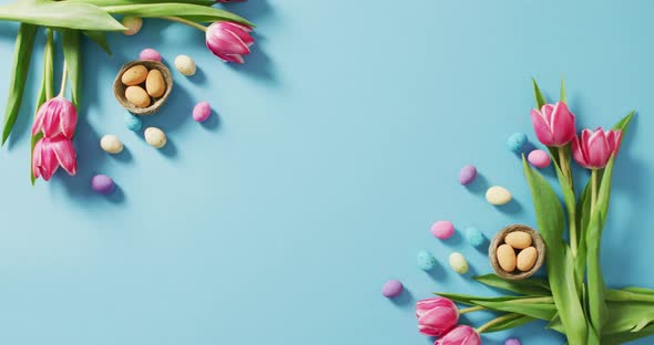 Video of decorated colorful easter eggs and flowers on a blue surface