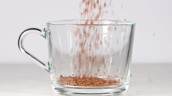 Pouring Granules of Instant Coffe Into Glass Cup