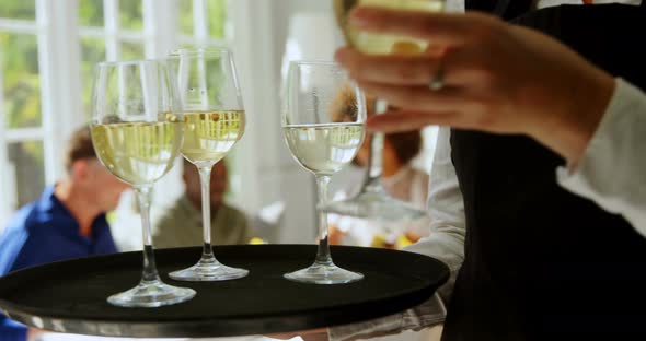 Waitress holding glasses of wine in tray