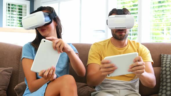 Couple using virtual reality headset in living room