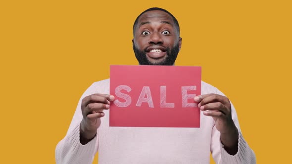 Amazed Young Black Man Guy Hold Banner with SALE Title on Yellow Background